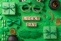 Top view photo of st patricks day decor wooden cubes labeled lucky day party glasses straws green bow-tie gift boxes horseshoe