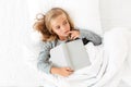 Top view photo of thoughtful little girl lying in bed with gray Royalty Free Stock Photo