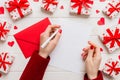 top view photo of valentine day decor female hands holding letter with envelope, small gift box and heart decoration on Royalty Free Stock Photo