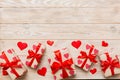 Top view photo of valentine day decorations gift box with red ribbon bow on colored background. Holiday gift boxes with