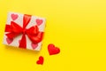 Top view photo of valentine day decorations gift box with red ribbon bow on colored background. Holiday gift boxes with