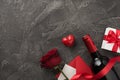 Top view photo of valentine`s day decor wine bottle white giftbox with red bow silk ribbon heart envelope with card and red rose Royalty Free Stock Photo