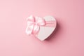 Top view photo of valentine`s day decorations heart shaped giftbox with pink ribbon bow on isolated pastel pink background with Royalty Free Stock Photo