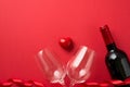 Top view photo of valentine`s day decorations red curly ribbon small heart between two wineglasses and wine bottle on isolated re Royalty Free Stock Photo