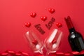 Top view photo of valentine`s day decorations red curly ribbon wine bottle small hearts and inscriptions love flying out of two Royalty Free Stock Photo