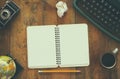 Top view photo of vintage typewriter, blank notebook, cup of coffee and old camera on wooden table. retro filtered image Royalty Free Stock Photo