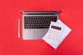 Top view photo of white calculator pen and notebook on grey laptop on isolated red background Royalty Free Stock Photo