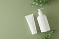 Top view photo of white cream tube, cosmetic bottle and eucalyptus leaves on pastel green background Royalty Free Stock Photo