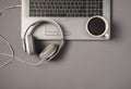 Top view photo of wired white headphones and cup of coffee on laptop keyboard on isolated grey background Royalty Free Stock Photo