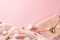 Top view photo of woman`s day composition pink leather purse soft cloth and white prairie gentian flower buds on isolated pastel