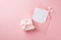 Top view photo of woman`s day composition white giftbox with pink silk ribbon bow open pink envelope with paper sheet and two Royalty Free Stock Photo