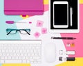 Top view photo of workspace with blank mock up tablet and smartphone, coffee cup, keyboard, and notepad on pastel background.