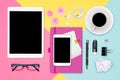 Top view photo of workspace with blank mock up tablet and smartphone, coffee cup, notepad and glasses on pastel background. Royalty Free Stock Photo