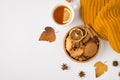 Top view photo of yellow knitted scarf yellow autumn leaves cup of tea and wooden bowl with cookies almond nuts anise dried lemon Royalty Free Stock Photo