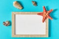 Top view of photoframe with seashells and starfish on blue background. Summer vacation concept. Royalty Free Stock Photo