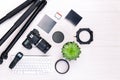 Top view of photographer workplace with dslr camera, lens and camera accessories on white wooden table. Royalty Free Stock Photo