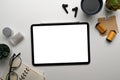 Top view photographer workplace with mock up digital tablet with empty screen, notebook, earphone and coffee cup on white table. Royalty Free Stock Photo