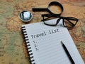 Top view phrase travel list with compass, eye glasses and magnifier on world map. Royalty Free Stock Photo