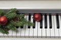 top view of piano with christmas tree branch and red christmas balls. New year or Xmas music concept. Royalty Free Stock Photo