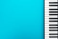 Minimalist photo of piano keyboard over turquoise blue background