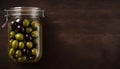 Top View of Pickled Olives in Jar on Wooden Table, Copy Space