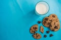 Top view picture of chocolate cookies and a cup of milk on blue background Royalty Free Stock Photo
