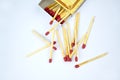 Top view picture of some flammable red fire matches scattered beside a small match box