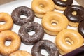 Top view picture of variety of assorted glazed donuts in a box. Unhealthy food concept