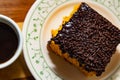 Coffee in a cup and carrot cake with chocolate icing. Royalty Free Stock Photo