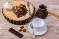 Top view of a piece of chocolate cake on wooden stump with a coffee cup, tea spoon, fork, anise, coffee beans, chocolate bar and b Royalty Free Stock Photo