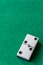 Top view of a piece of dominoes, with the number two double on green mat to play, vertically Royalty Free Stock Photo