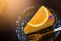Top View of a piece of orange cake and sliced orange topping with spoon. Cake with orange mousse with copy space