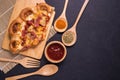 Top view piece of pizza on wooden plate and black stone table