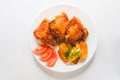 Top view of Pieces of fried chicken with fried potatoes and tomatoes on a white plate Royalty Free Stock Photo