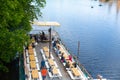 Top view of the pier with rows of tables for waiting and resting. People are resting by the water