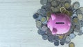 Piggy bank with coin on wood table background