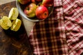 Top view of pile of apples in a bowl with cut one next to it