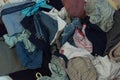 Top view of a pile of clothes. Various colors and textures. Overconsumption and clutter concept