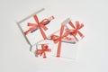 Top view of a pile of gift boxes of different sizes with red bows on white background