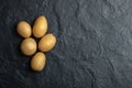 Top view of pile of potatoes. Fresh potatoes on black stone background