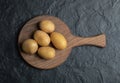 Top view of pile of potatoes on wooden cutting board