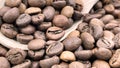 Top view of a pile of scattered aromatic roasted brown coffee beans with a wooden scoop. Coffee beans in a wooden spoon