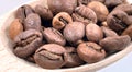 Top view of a pile of scattered aromatic roasted brown coffee beans with a wooden scoop. Coffee beans in a wooden spoon Royalty Free Stock Photo