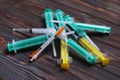 Top view of a pile of syringes and insulin syringes ready for injection at wooden background. Health care concept with