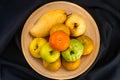 Top view pile of various ripe sweet tropical fruits in bamboo tray