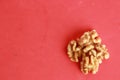 Top view of a pile of walnuts under the lights on a pink background