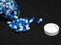 Top view of pill capsules spilling out of an open transparent bottle Royalty Free Stock Photo