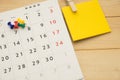 Top view. pin putting on desktop calendar and have post-it note Royalty Free Stock Photo