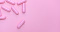 Top view of pink capsule on pink background with copy space. Pharmacy banner. Online pharmacy. Pink background for love addict and