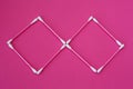 Top view on pink cotton buds with white heads laid out in rhombus form on a pink background